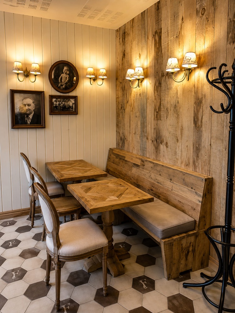 Restaurant corner banquette in reclaimed timber with parquet-top tables and spindle-back chairs