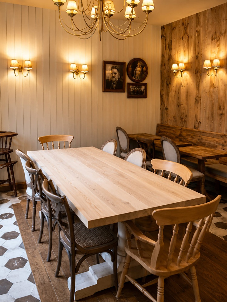 Private dining room with a long solid-ash table and mixed wooden chairs under wall panelling