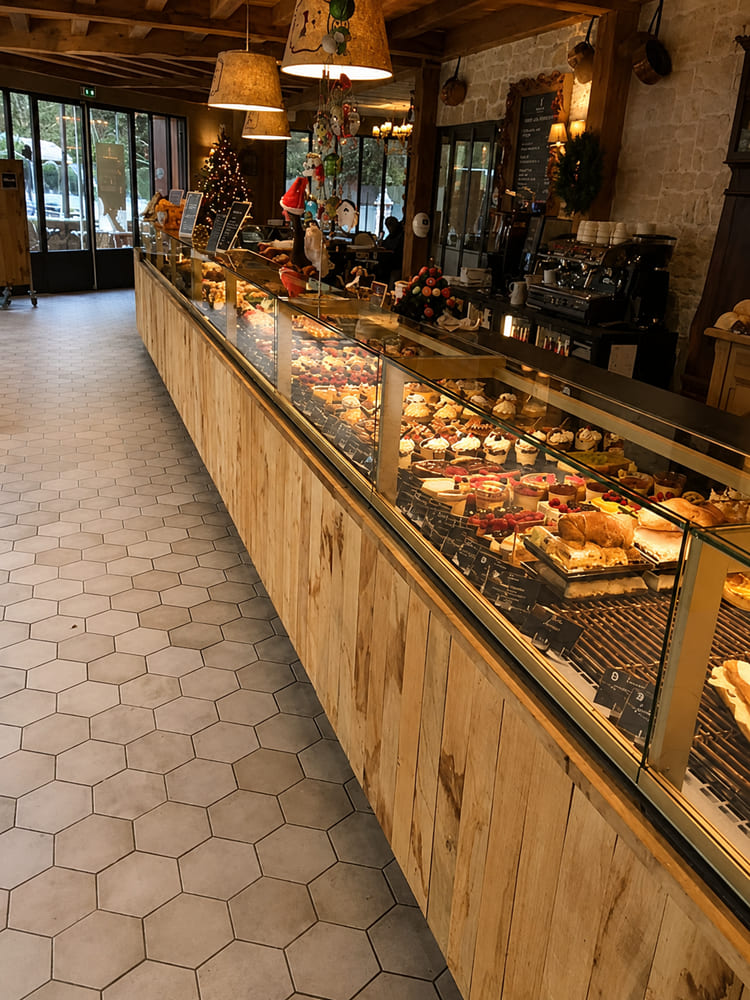 Long timber-clad patisserie display counter with a glazed pastry cabinet
